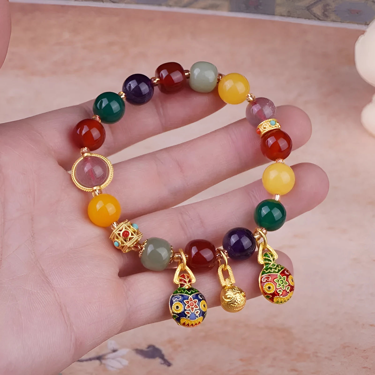 Hand-woven agate bracelet with 10mm swallowing gold beast beads on display