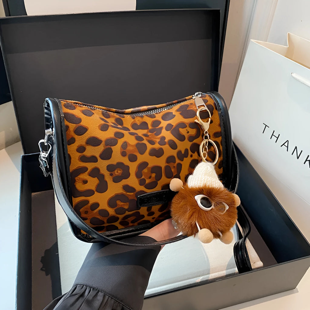 High-textured PU messenger bag with leopard print, horizontal square shape, and decorative pendant