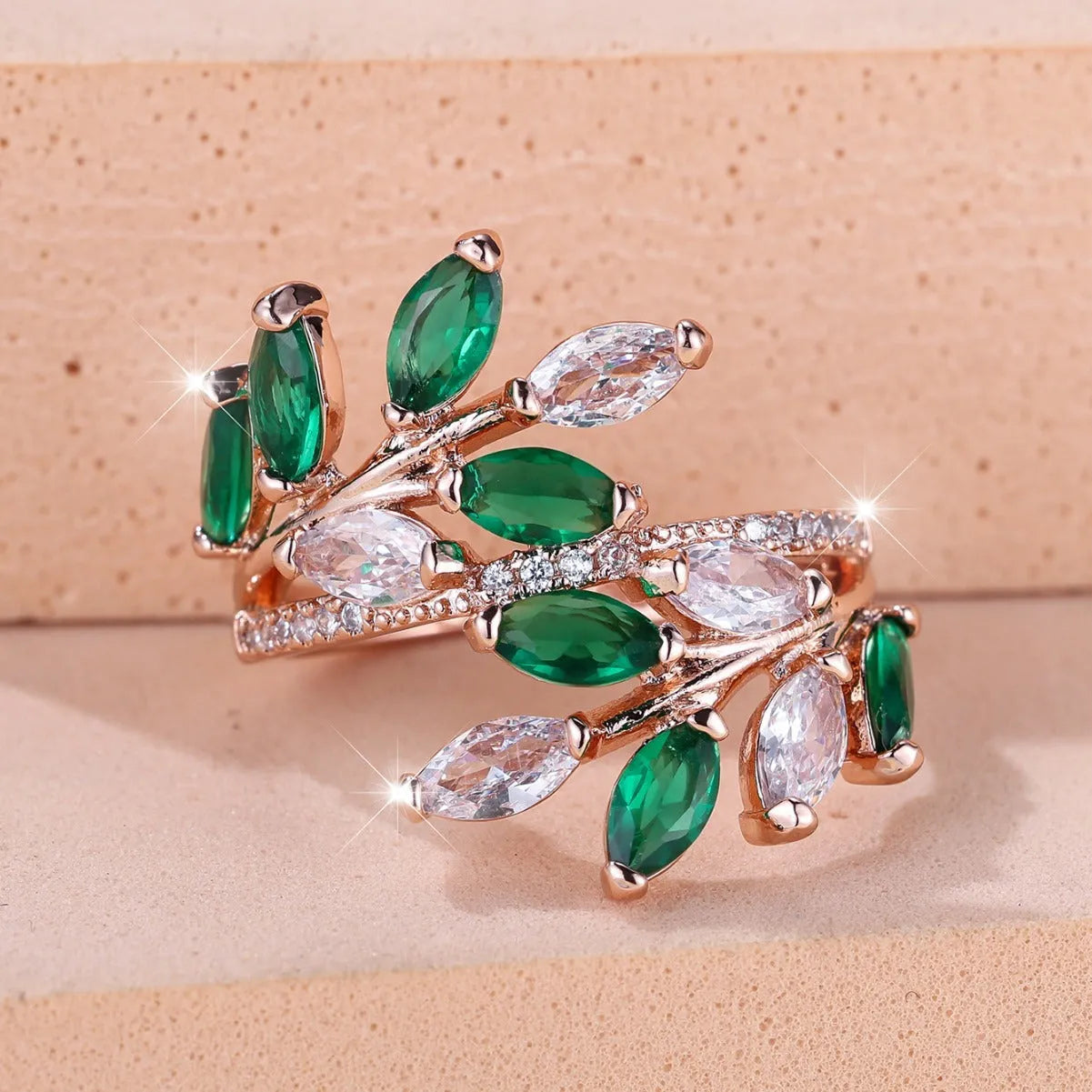 Adjustable copper leaf fashion ring with a central zircon stone on a model's hand, showing rose gold and platinum colour variants.