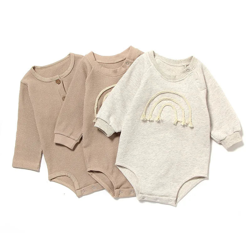 Baby wearing long sleeve waffle cotton romper with either cotton rope ties or button front closure in beige, khaki, green or blue
