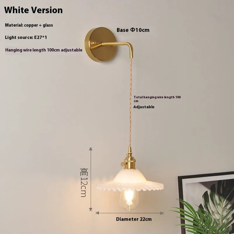 Retro brass lotus wall lamp with glass shade mounted on a wall, showing copper fittings.
