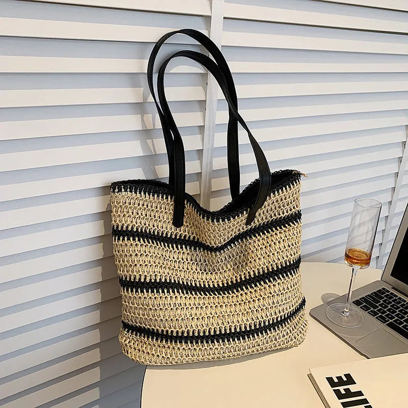 Large striped straw woven handbag with 64cm shoulder strap and polyester lining, shown in khaki or black