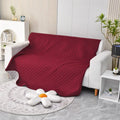 Reversible waterproof dog blanket laid on a sofa, showing two colour options.