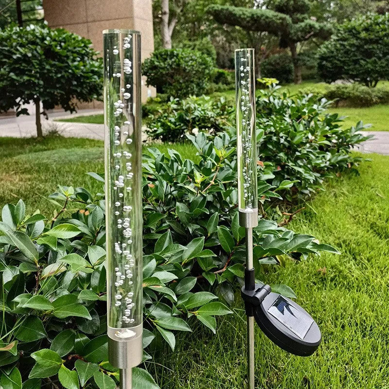Solar bubble stick lawn lamp with colourful slow-flash crystal effect and warm light on a garden lawn