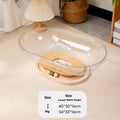 Transparent acrylic space capsule cat bed with a turntable base on a wooden floor.
