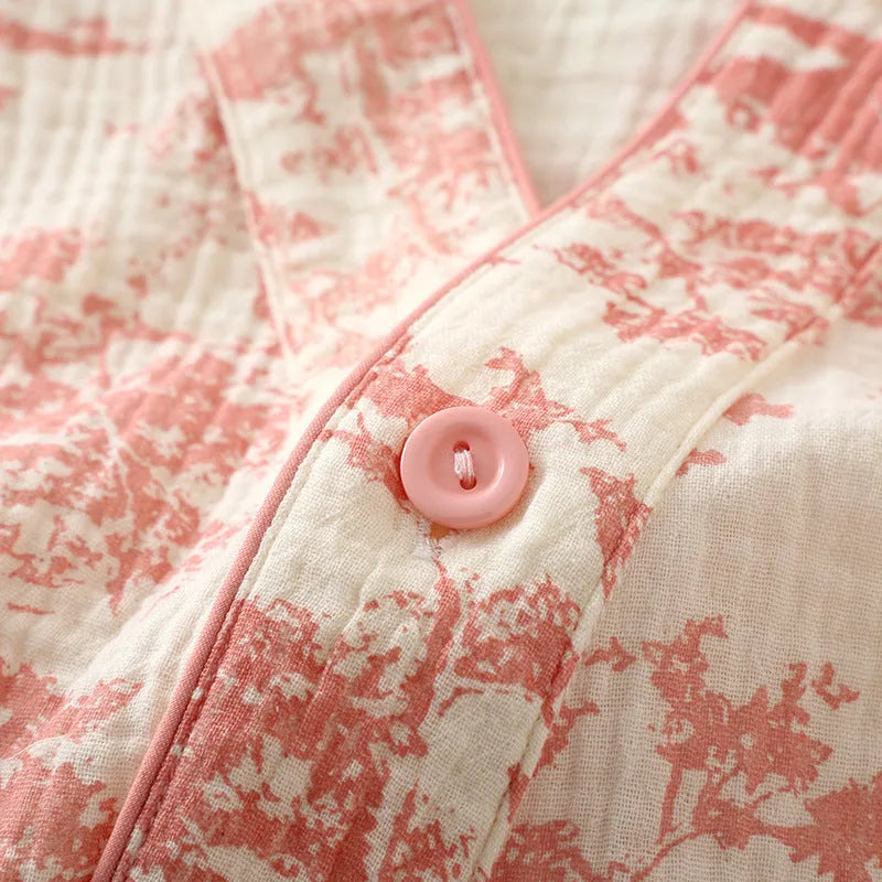 Women's pink cotton gauze lounge suit set with long sleeves and elastic waist trousers laid flat.