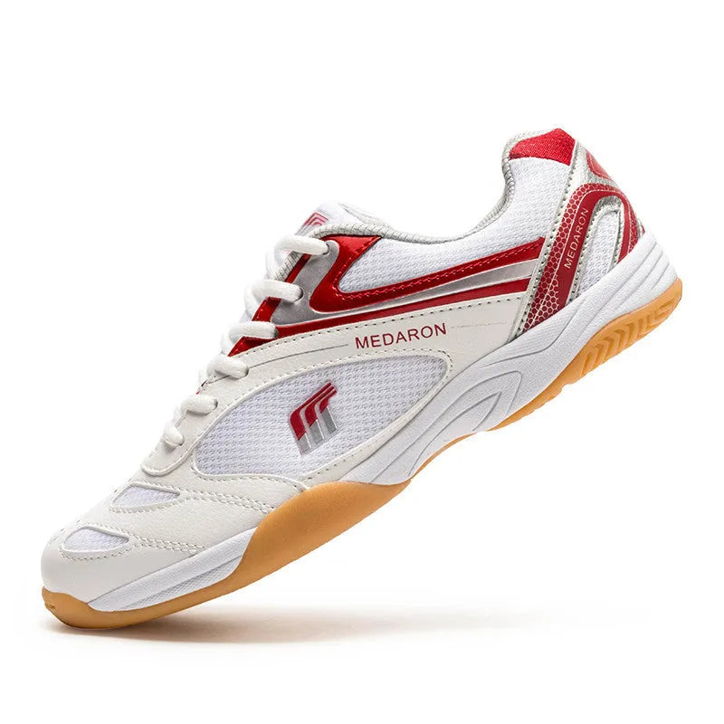 Table tennis sneakers in white and red colour with mesh upper, natural rubber outsole and front lace-up closure