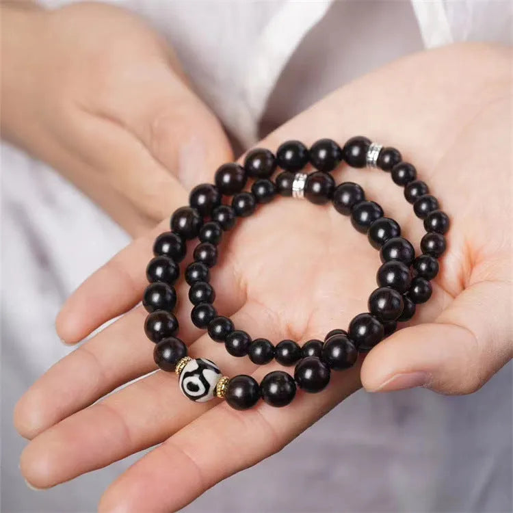 Dark ebony wood bracelet with 8mm Tibetan style beads showing two-circle pattern design