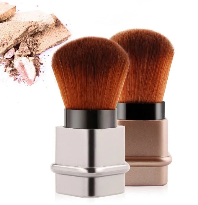 Portable single makeup brush with man-made fibre bristles and square gold plastic handle on white background