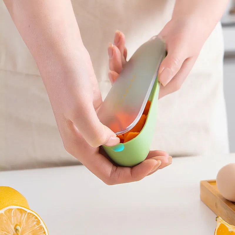 Dark green kitchen peeler with storage tube and stainless steel blade on a worktop.