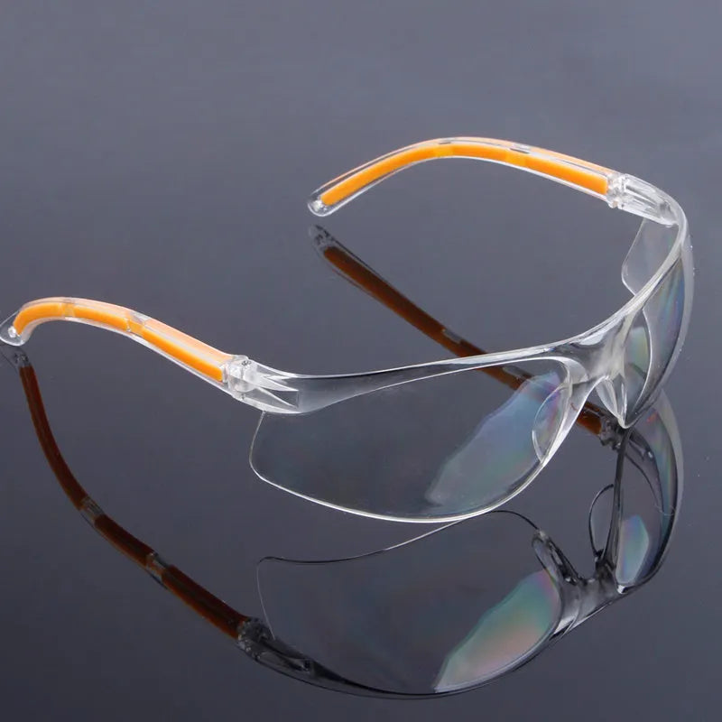 Transparent polycarbonate safety goggles with yellow frame for industrial and lab eye protection.