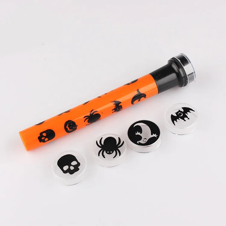 Orange metal pumpkin skull flashlight projection lamp on a plain background