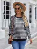 Black and white plaid print long sleeve pullover sweater for men on a neutral background.