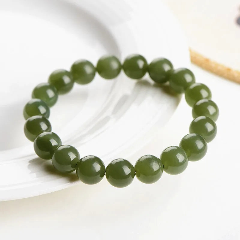 Polished Hetian jade ball bracelet on a wrist, showing spherical beads in a clear, ice-like colour.