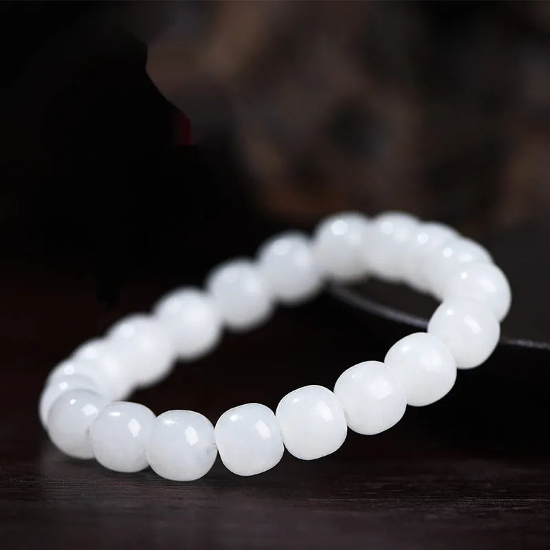 White Hetian jade barrel bead bracelet showing smooth, polished beads on a wrist.
