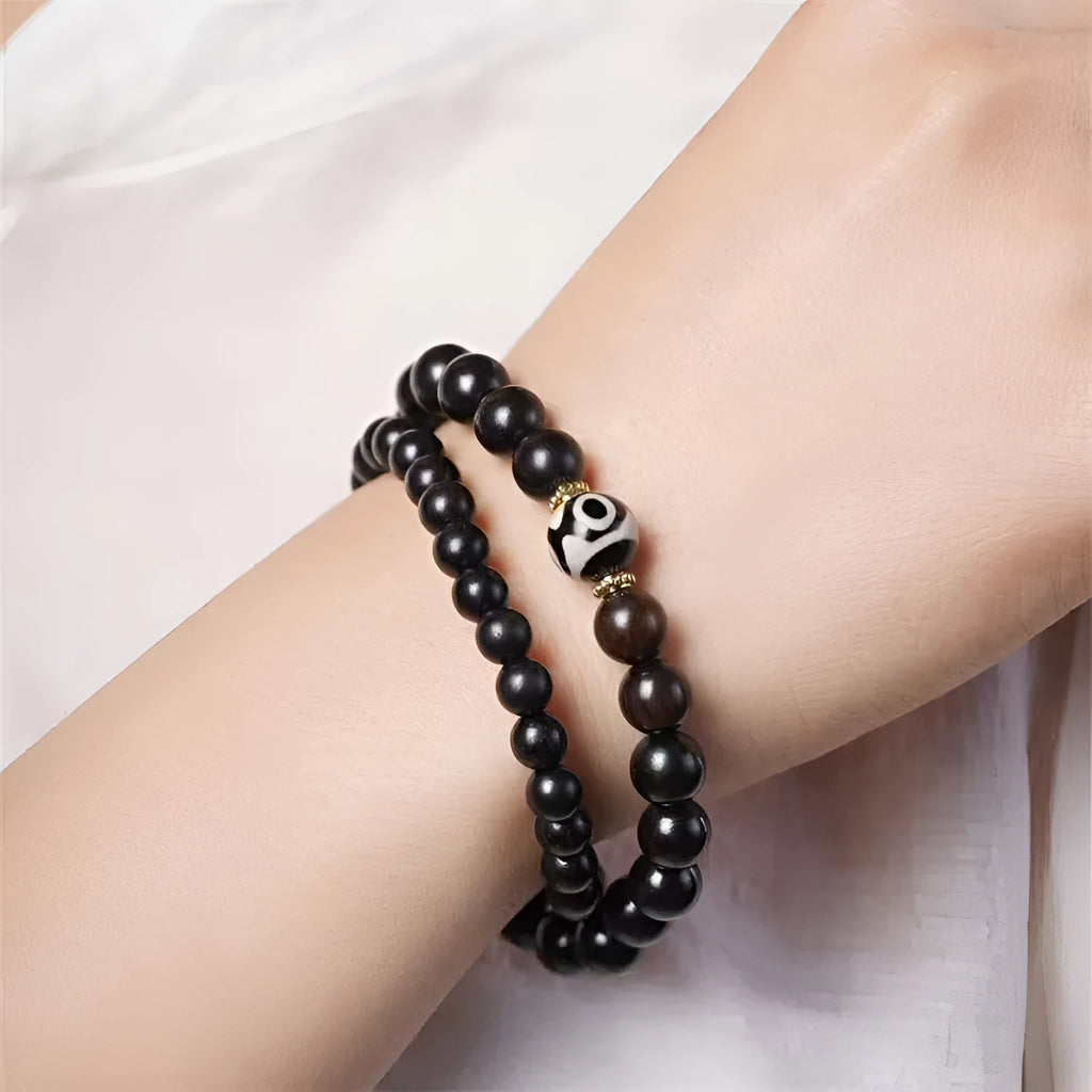 Dark ebony wood bracelet with 8mm Tibetan style beads showing two-circle pattern design