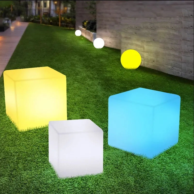 White square LED cube light stool on grass, showing modern design and waterproof build for outdoor use.