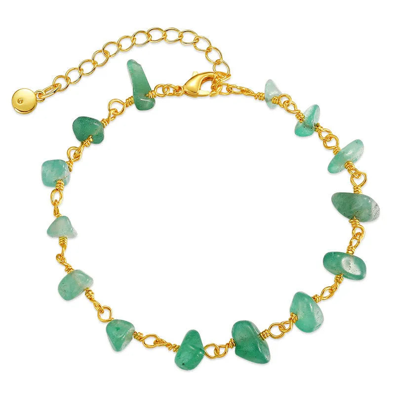 Geometric women's copper bracelet with irregular turquoise gravel stones and crystal accents on a white background.