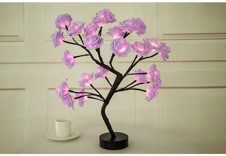 White and red rose flower LED table lamp with bonsai tree garland on a wooden table.