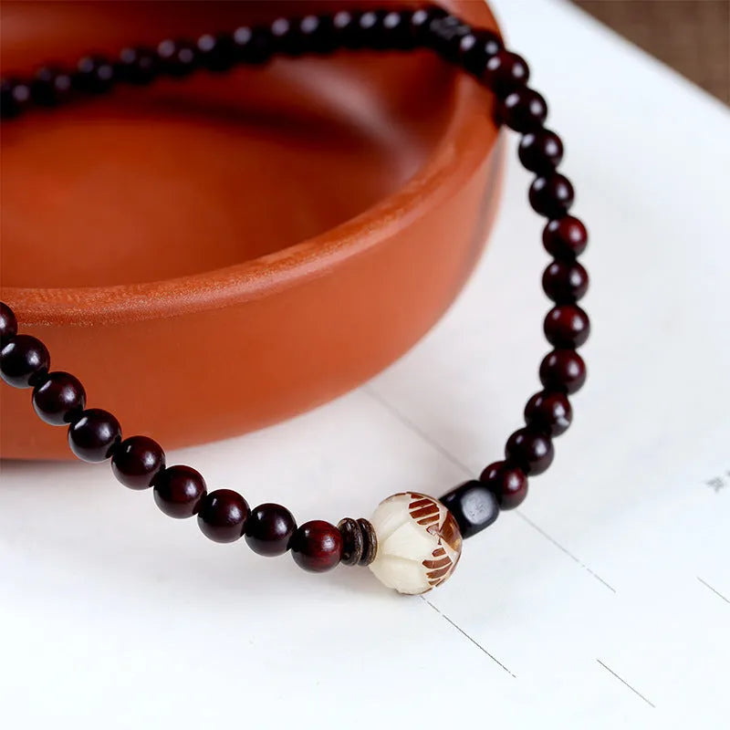 Rosewood bracelet with knitted construction showing floral carving details and 10mm diameter