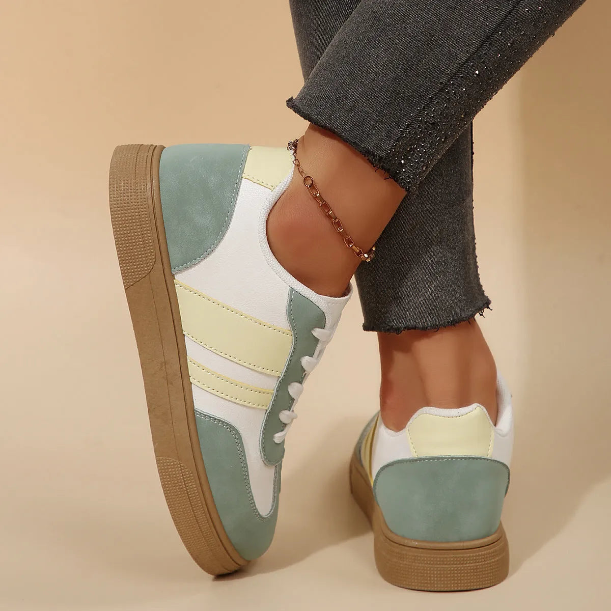 Green women's low-top retro sports shoes with cross straps and a flat rubber sole.