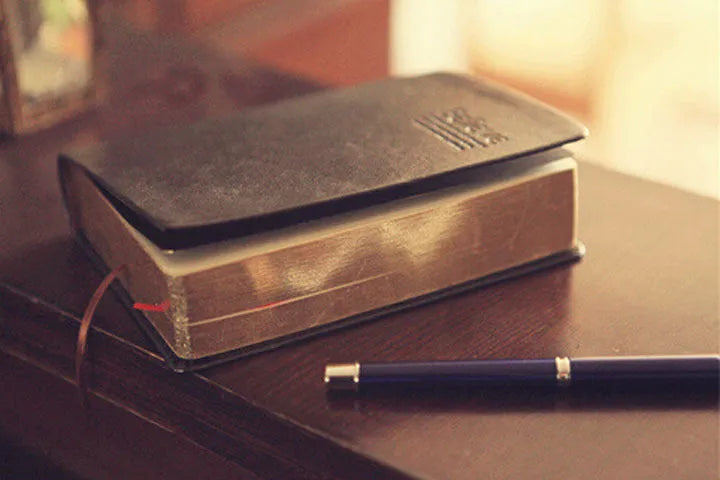 Large thick leather Phnom Penh notebook in gold, A6 size, 480 pages, open on a desk