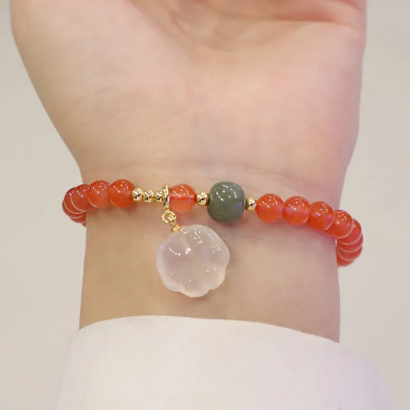 Polished agate bracelet with cat's paw charm and jade beads on adjustable cord.