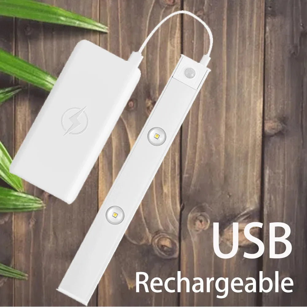 Silver ultra-thin wireless LED strip light with motion sensor attached to a kitchen cabinet door.