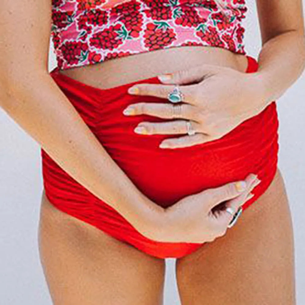 Red high waist maternity swimsuit with matching swim trunks on a pregnant woman
