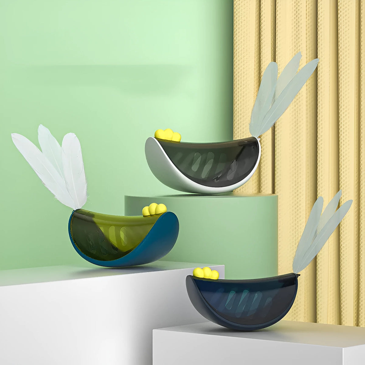 Cat toy tumbler in grey with feather accents on a light background, showcasing playful rolling design