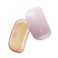 Pink handheld electric pet massage brush with soft TPE teeth on a white background