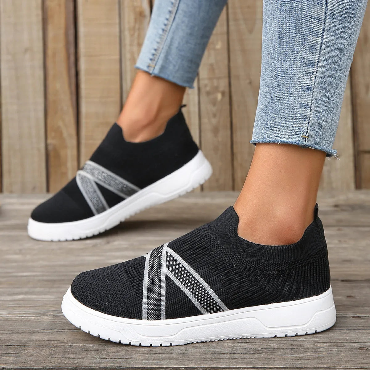 Black women's low-top flyknit mesh flat shoes with round toe and tassel detail on a rubber sole.