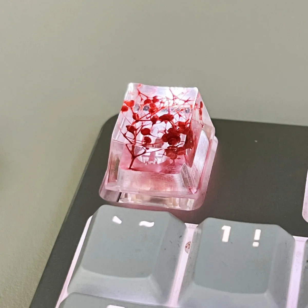 High transparency resin keycap with starry sky pattern in green, shown next to a mechanical keyboard.