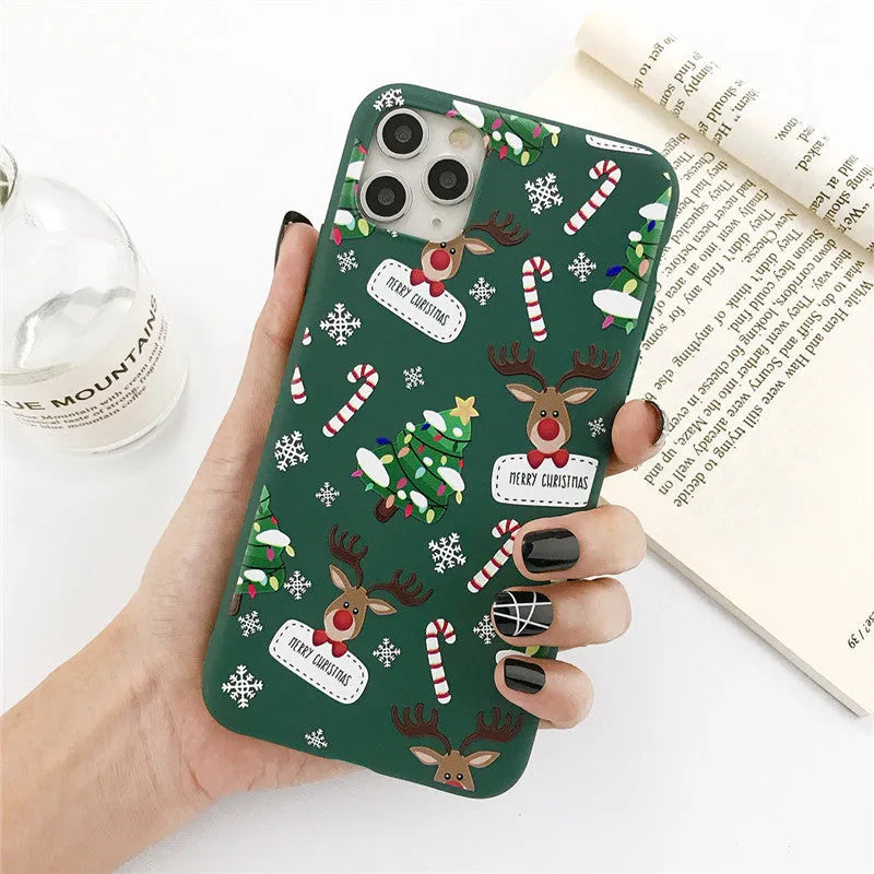 Green iPhone case with a cartoon Christmas tree and elk design on a flexible TPU back cover.