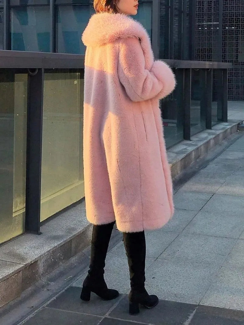 A woman wearing a thick grey faux rabbit fur mid-length coat with a fur collar.