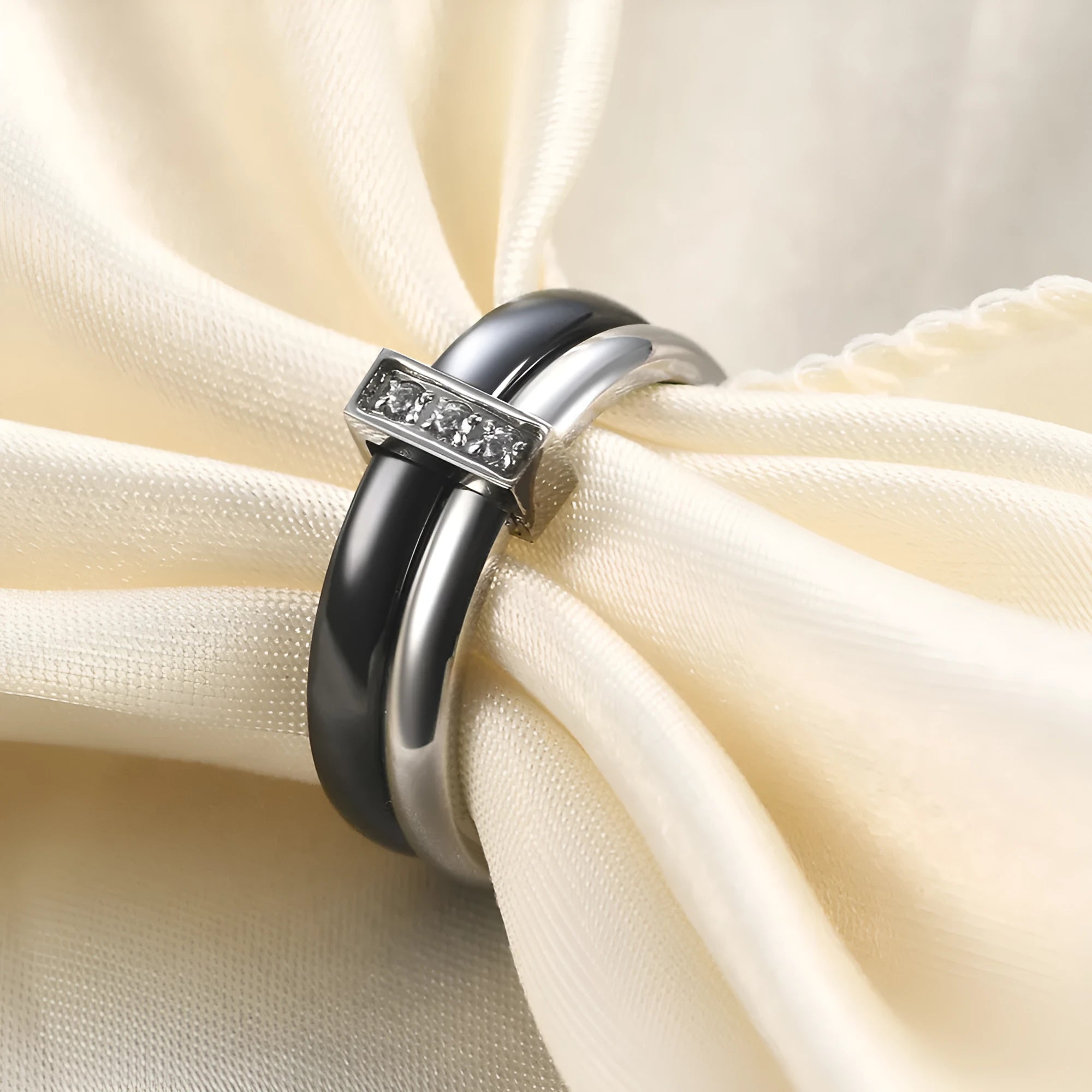 A Steel Black ceramic women's ring with glossy stitching and inlaid zirconium stones on a wooden surface.