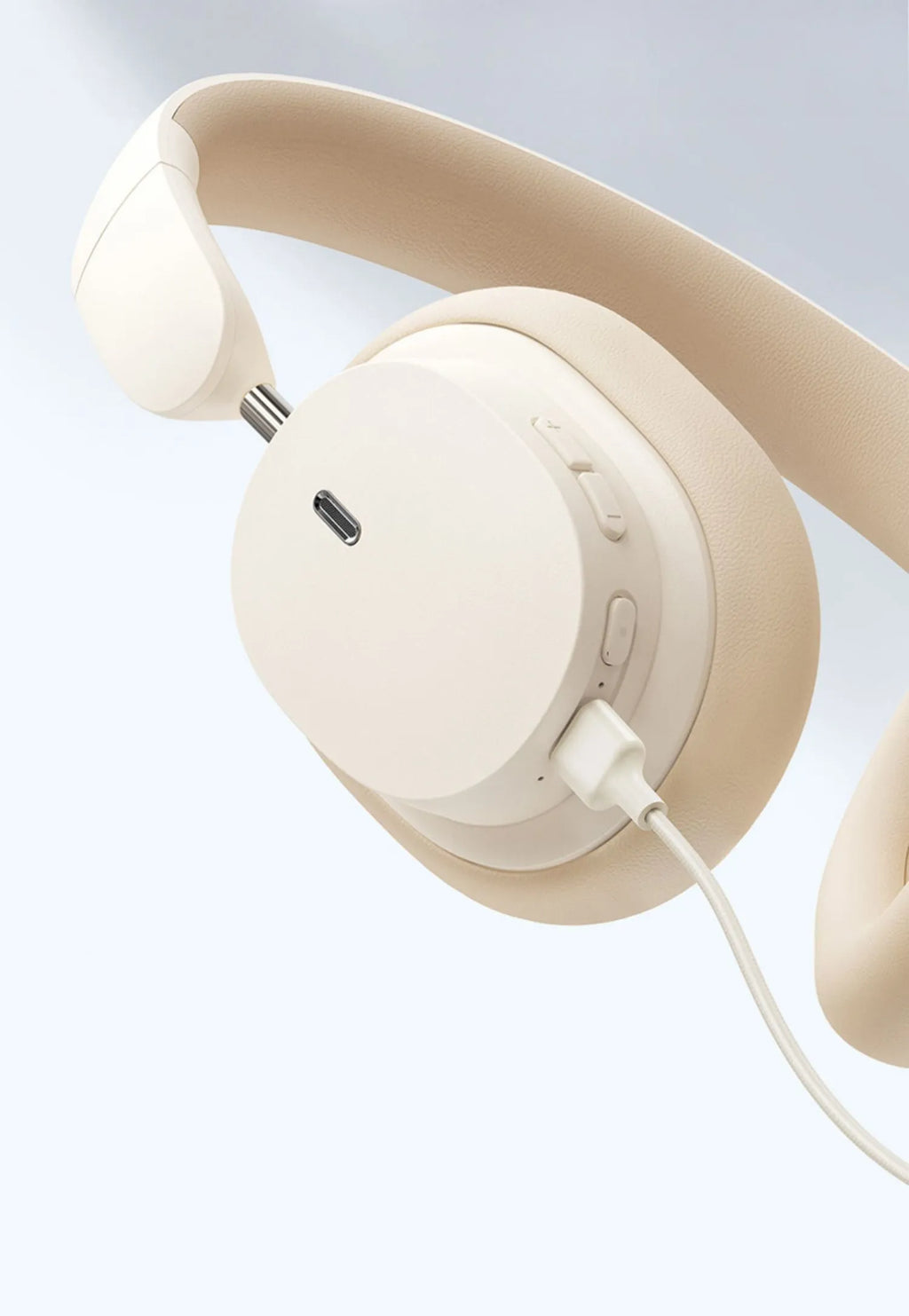Beige Bluetooth over-ear headphones with cushioned ear cups and metal headband