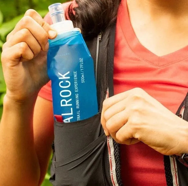 Flexible plastic suction straw with silicone mouthpiece, shown extended and collapsed next to a cycling water bottle.