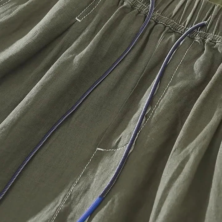 Men's loose straight leg linen shorts in green with drawstring waist and mid thigh length