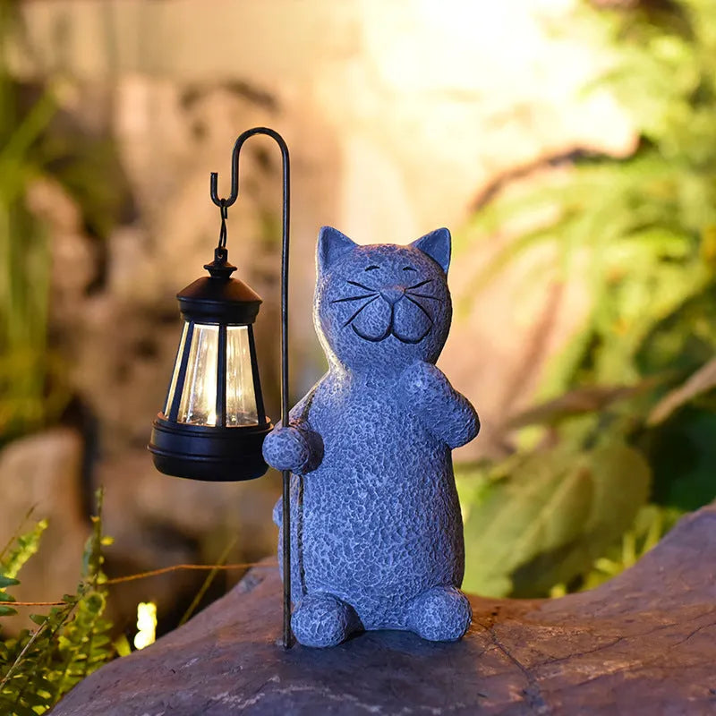 Solar-powered garden light with decorative resin kitten ornament lifting a lamp.