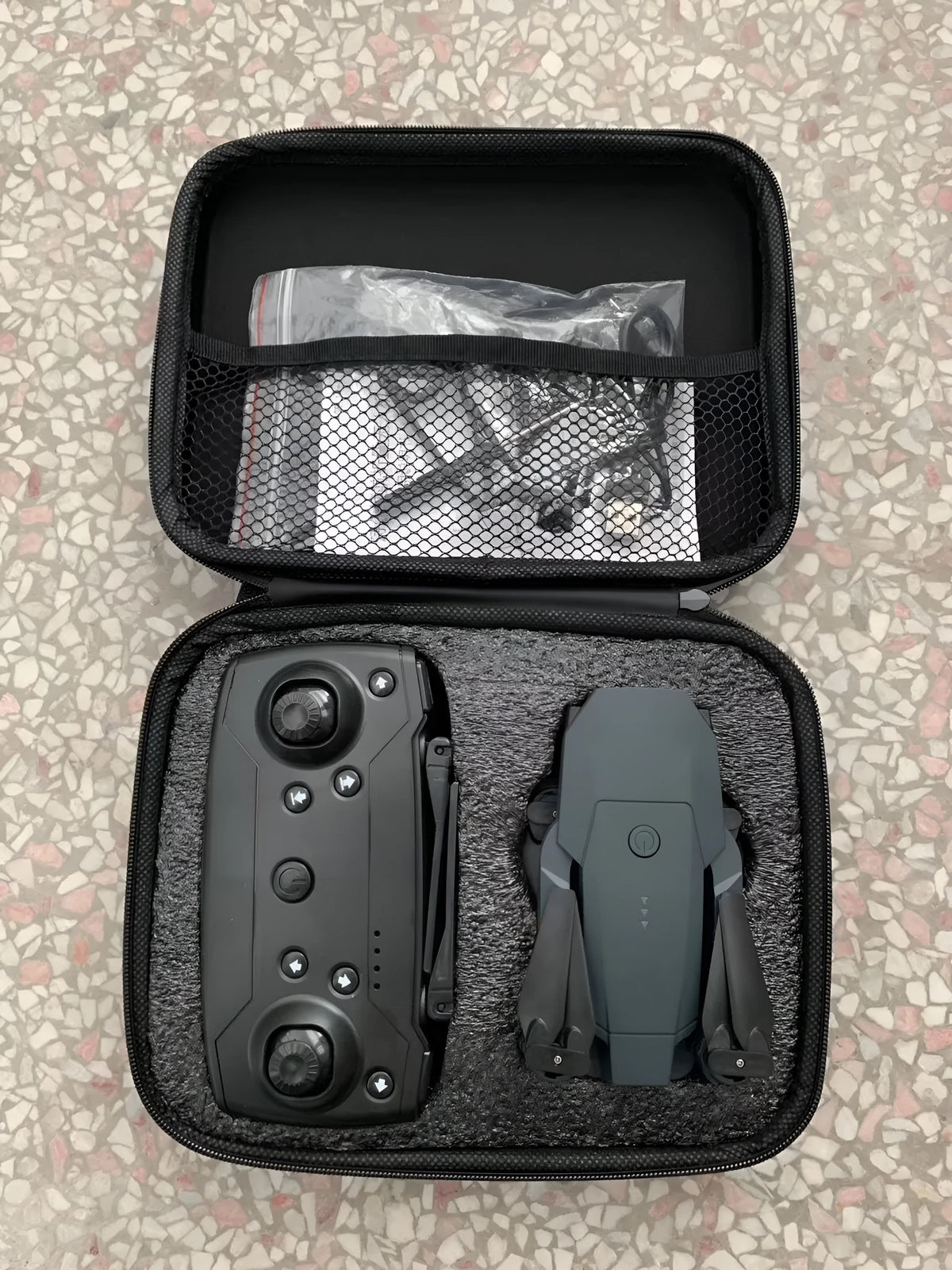 Folding plastic aerial drone with high-definition wide-angle camera, 26cm body, folded to 12cm, on a plain background