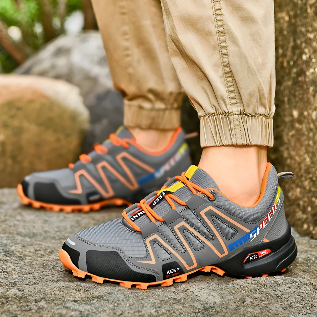 Men's grey orange and dark blue casual running shoes with low-top design on a white background.