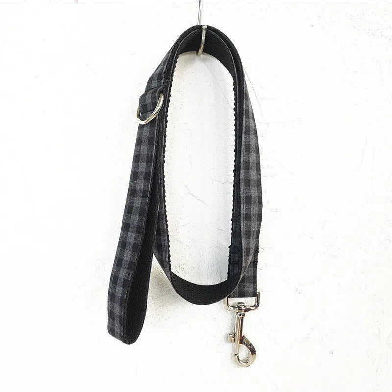 Black polyester dog training leash with metal chain ring on a plain background