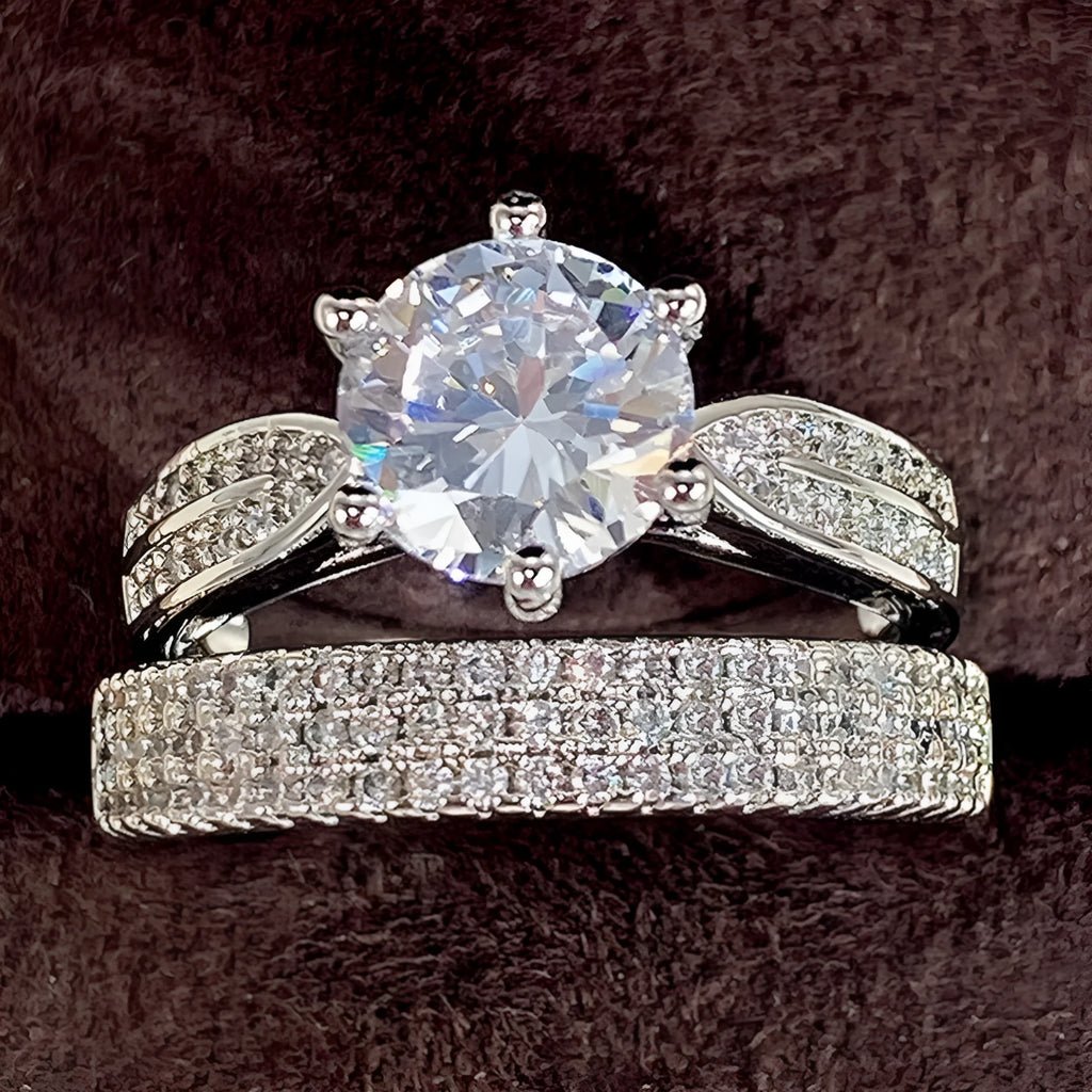 White gold coloured alloy geometric wedding ring bracelet with a round element on a size 7 finger.