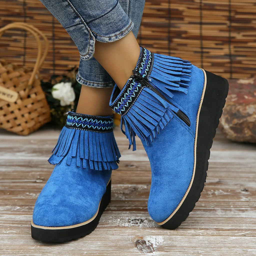 Women's black wedge bootie with suede upper, thick rubber sole, side zipper, and tassel detail.