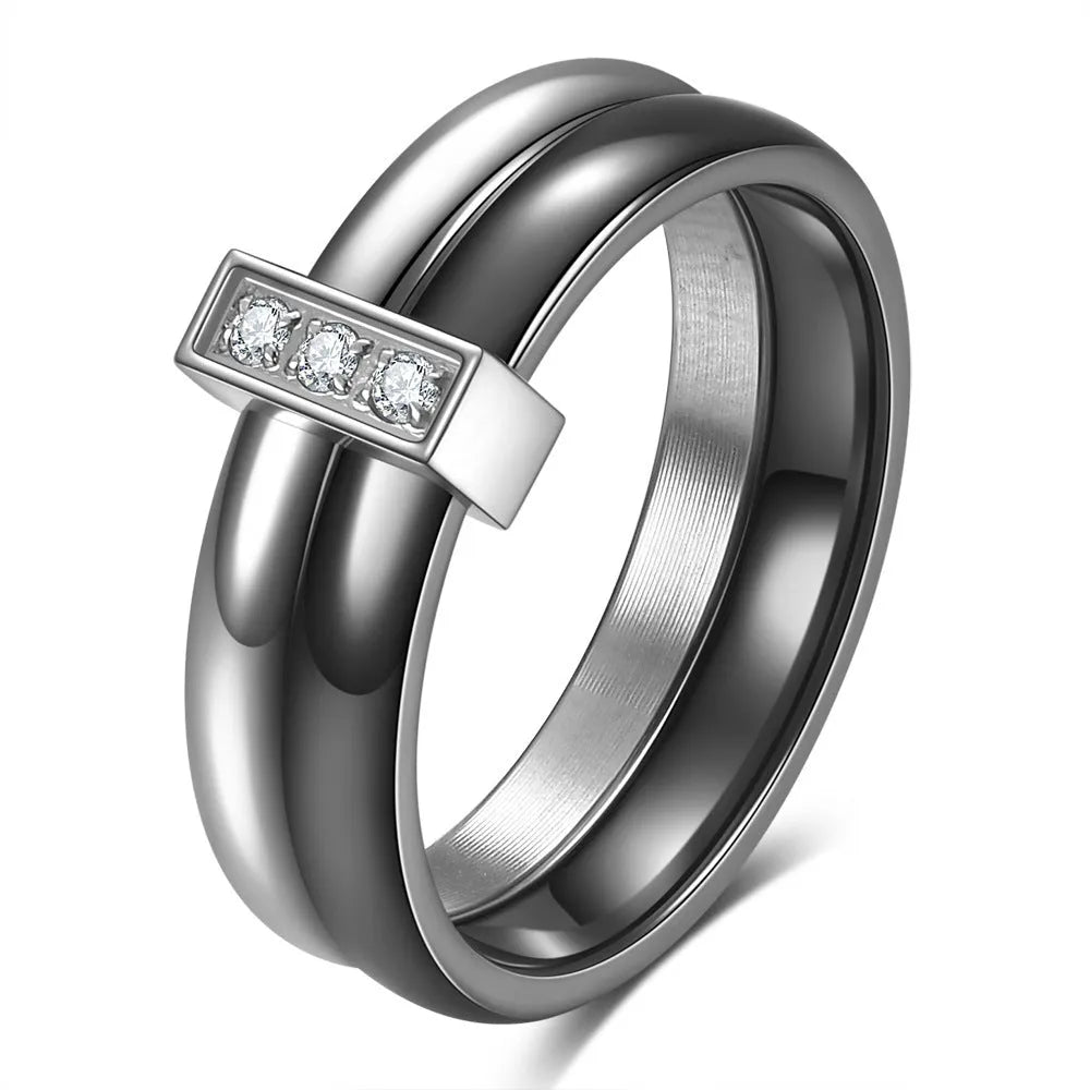 A Steel Black ceramic women's ring with glossy stitching and inlaid zirconium stones on a wooden surface.