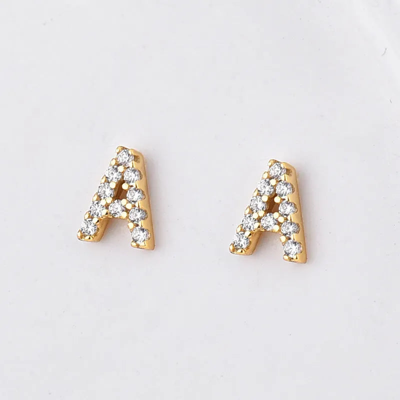 Gold plated alphabet letter earrings showing brass construction with zircon detail on English letters