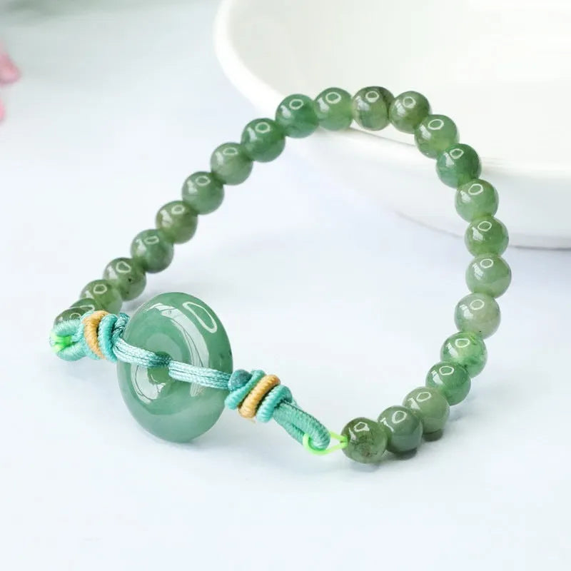 Emerald green jade bracelet with safety buckle closure and star charm on wrist