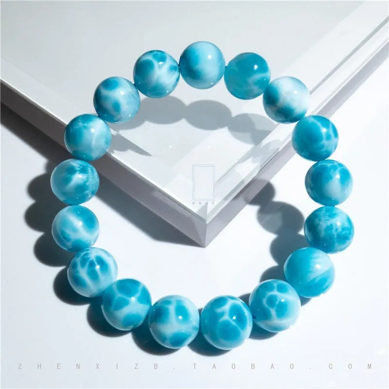 Blue handmade Bodhi bead bracelet with natural crystal and sea-pattern stone on a wrist.
