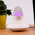 Levitating floating speaker with magnetic suspension, cast FRP body, black colour, hovering above base on a desk